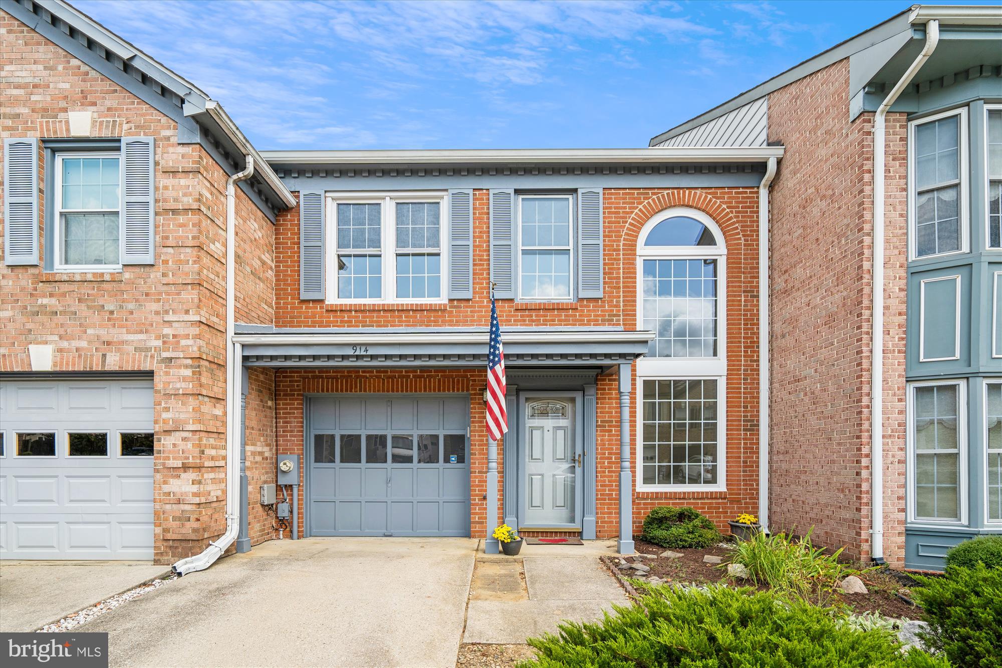 front view of a brick house with a small yard