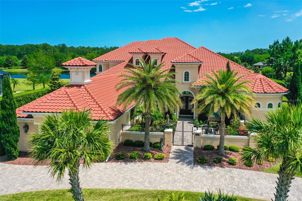 a palm tree sitting in front of a house with a yard