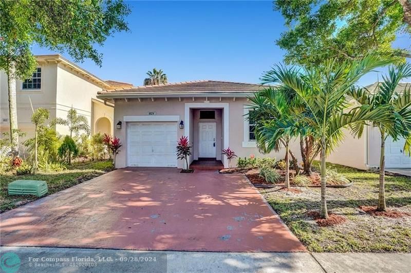 a view of a house with a yard and palm trees