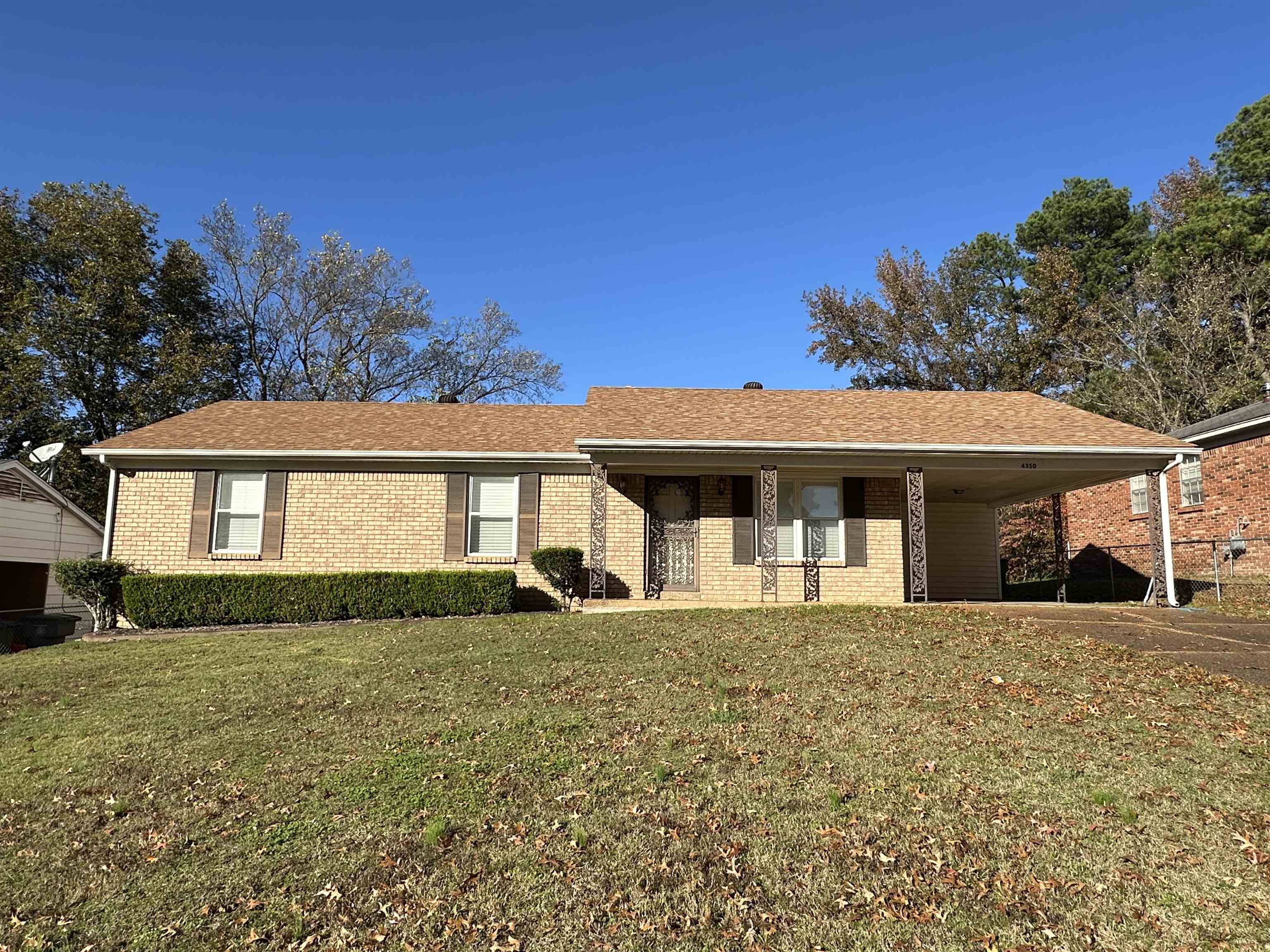 Ranch-style house featuring a front lawn and a carport