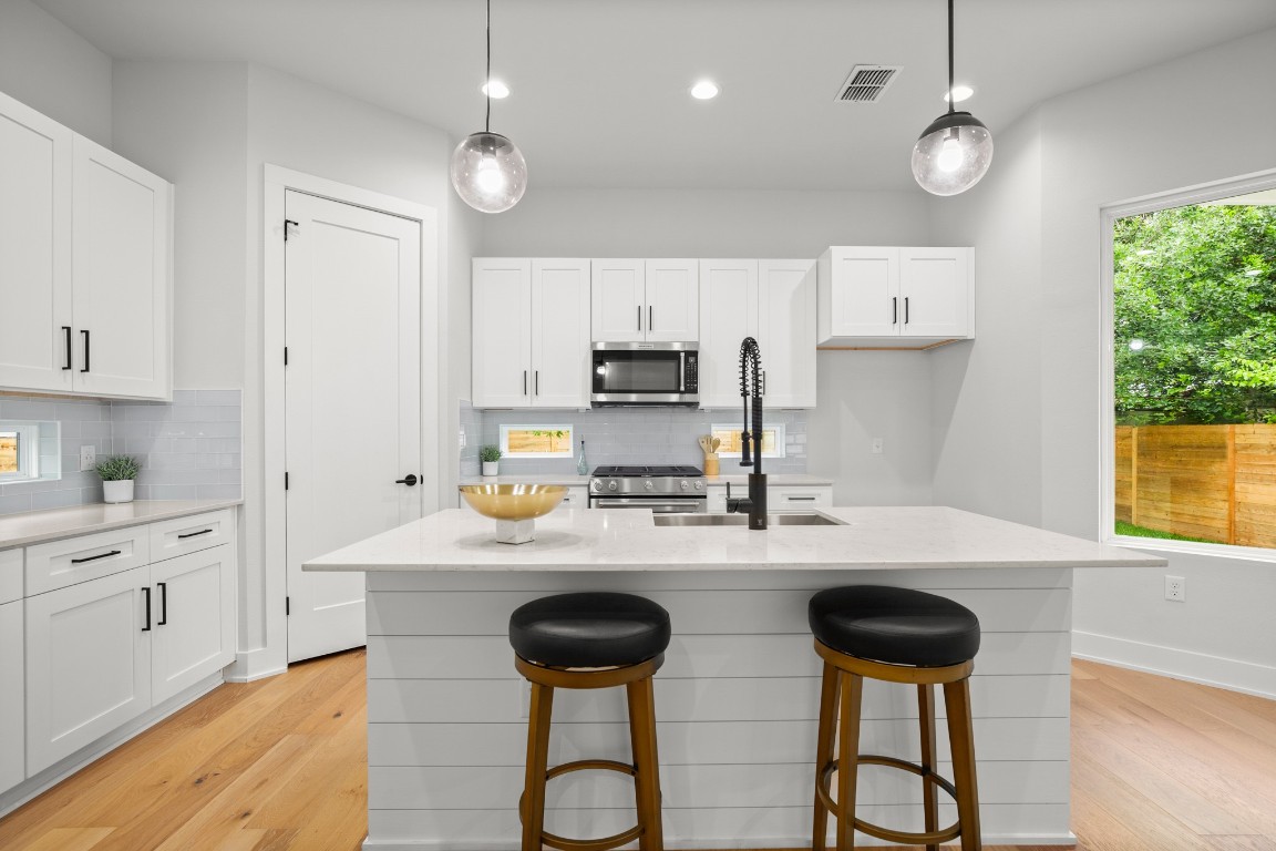 a kitchen with appliances a sink and cabinets