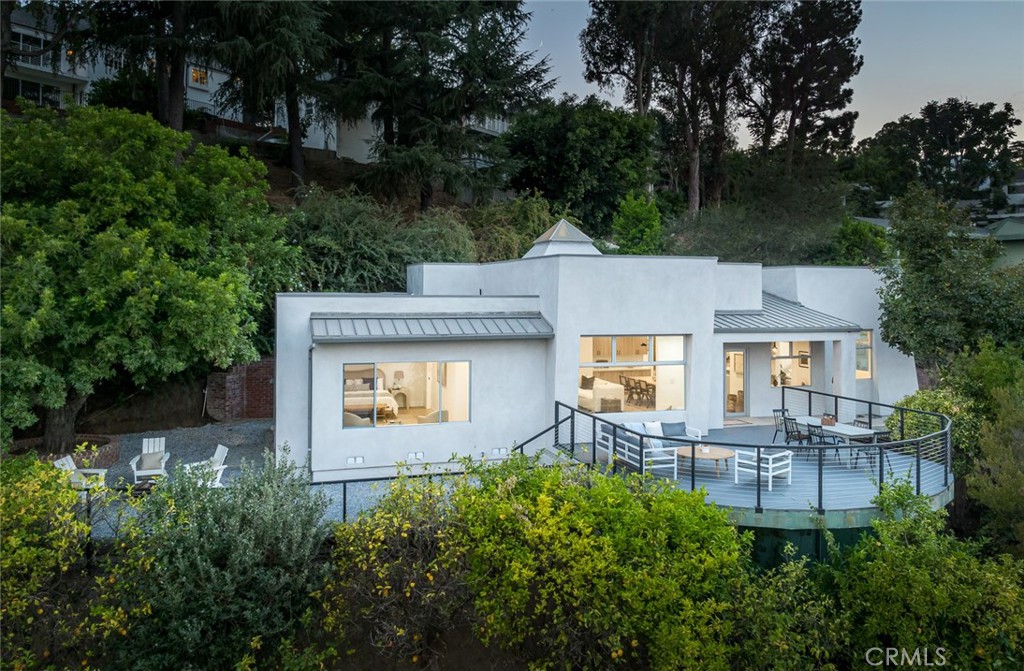 an aerial view of a house with table and chairs and a large tree