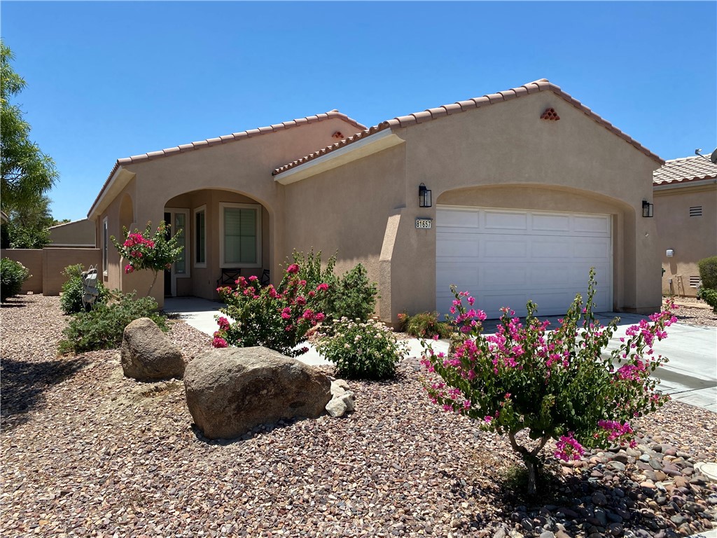 a front view of a house with a flower garden