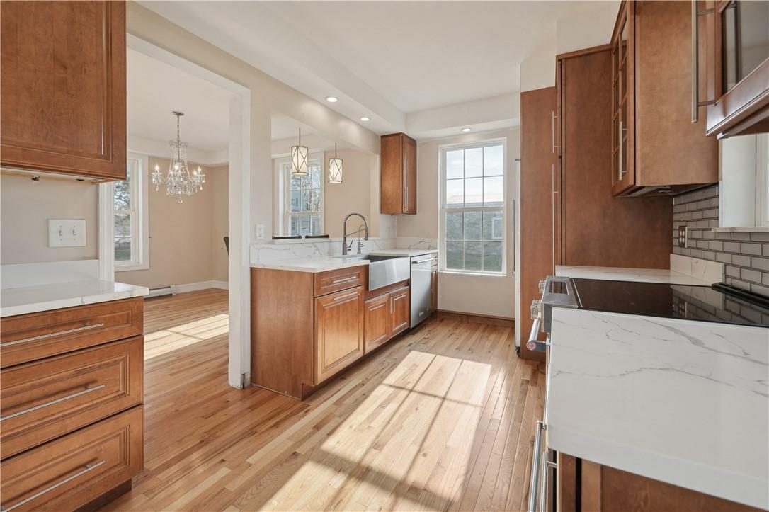 a large kitchen with stainless steel appliances granite countertop a lot of counter space and wooden floors