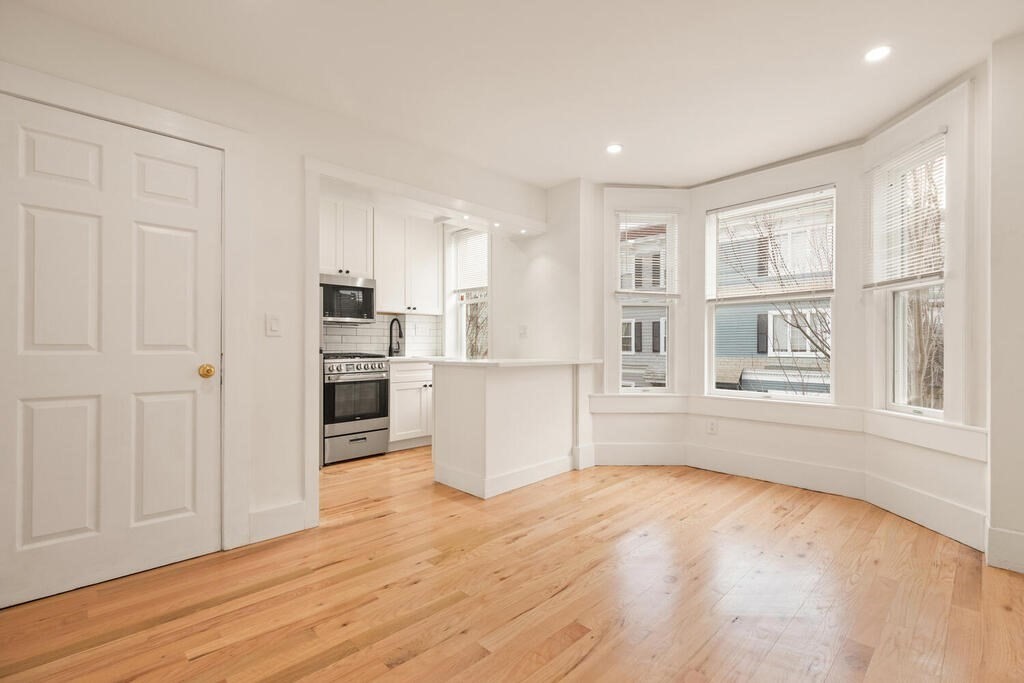 a view of a kitchen with wooden floor and windows