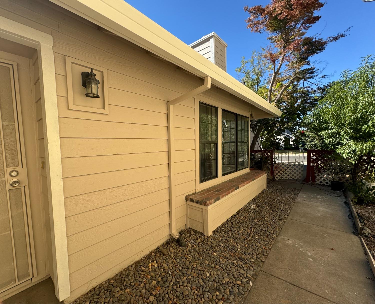 a view of a house with a door and wooden bench