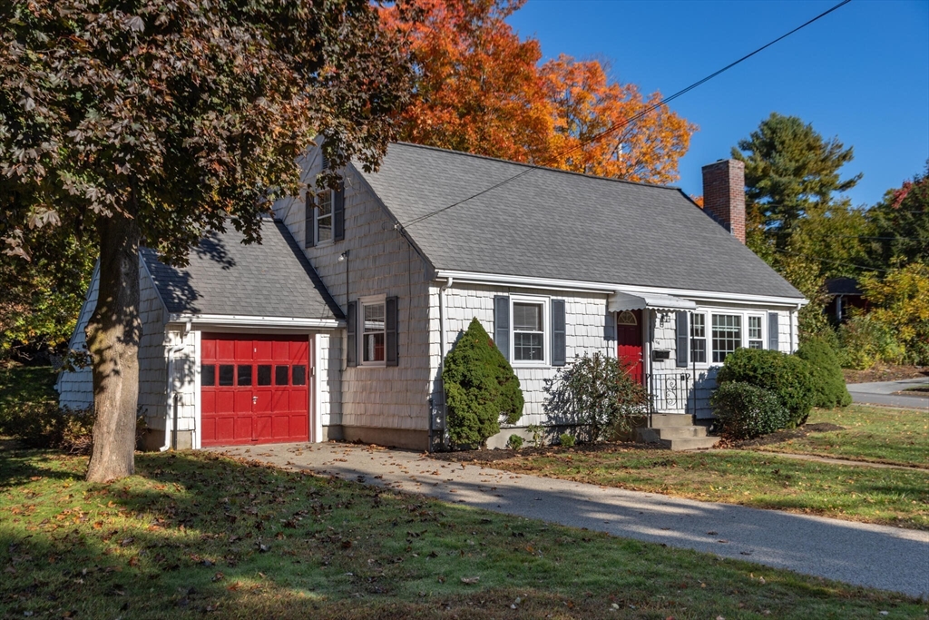 a front view of house with yard and trees around