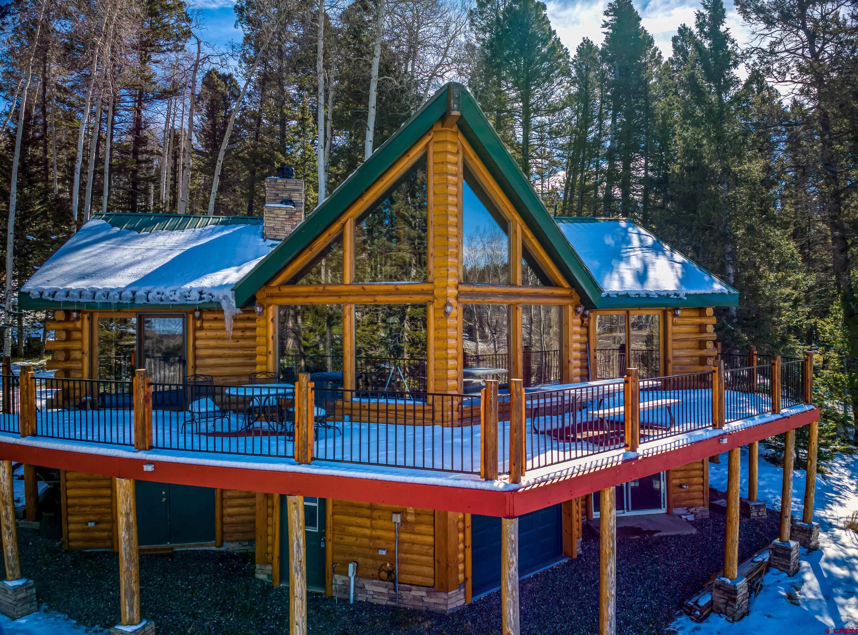 a view of wooden house with a small yard and deck