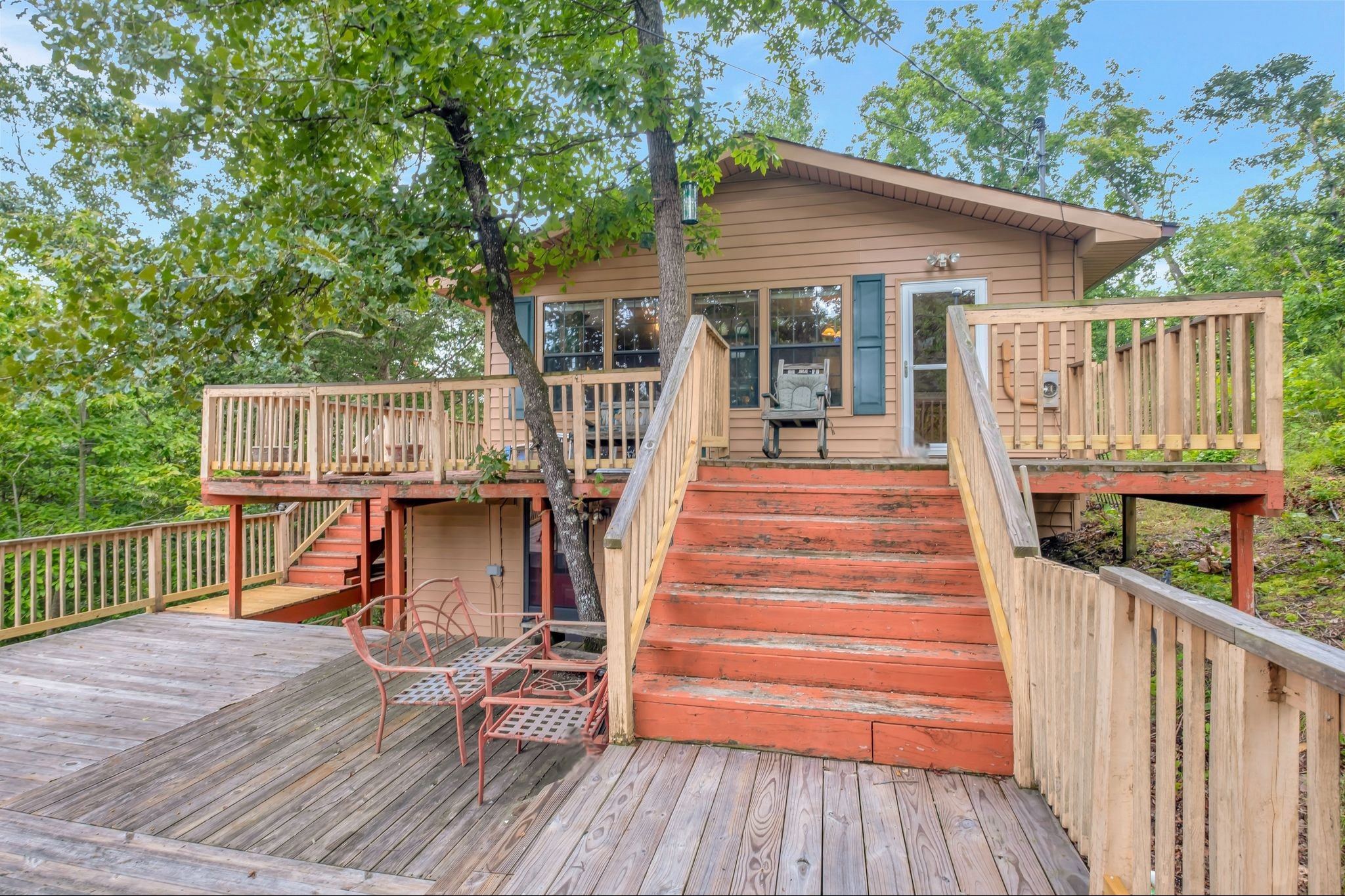 a view of a deck with wooden floor and fence next to a yard