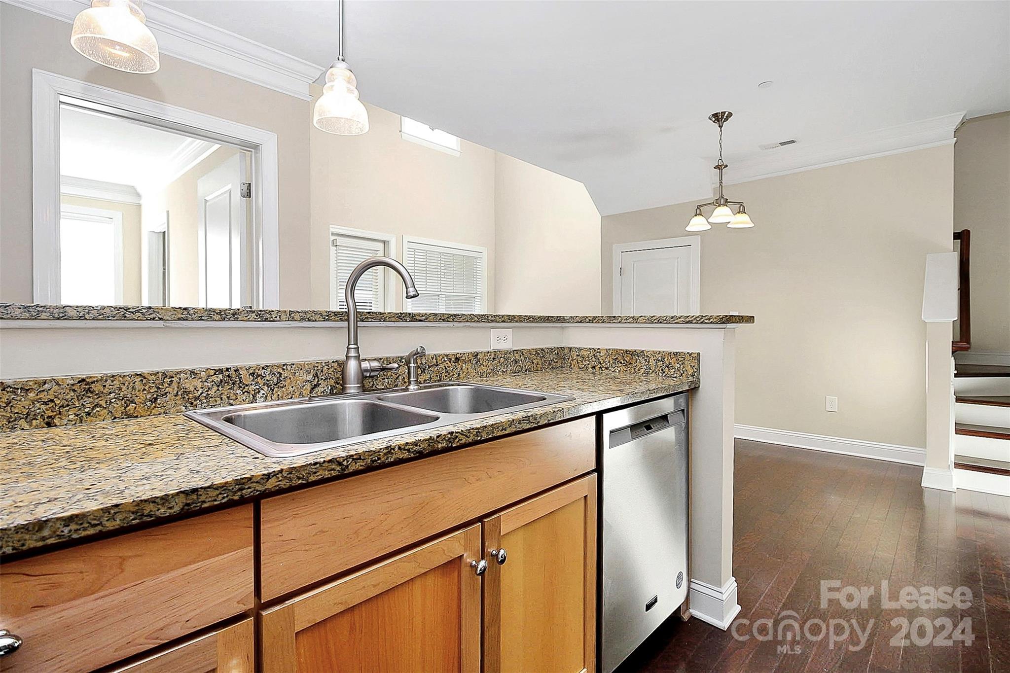 a kitchen with granite countertop a sink and a white cabinets