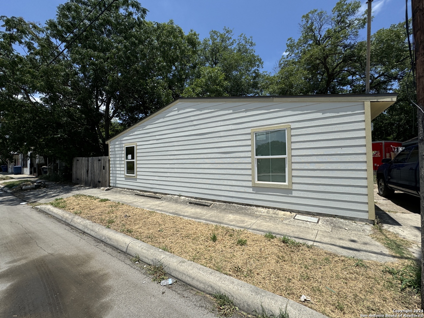 a view of a house with a yard and large tree