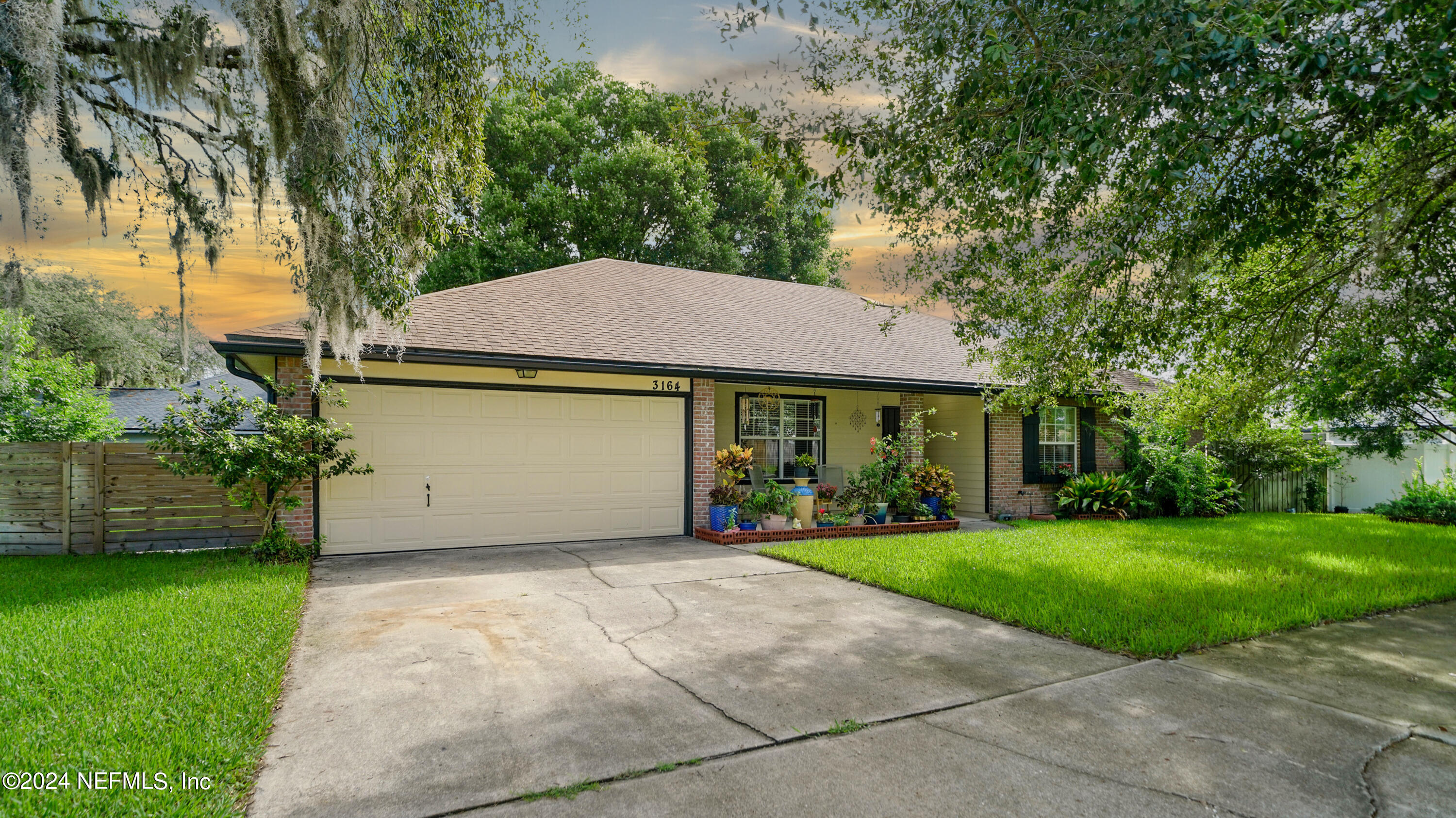 a front view of a house with a yard and trees