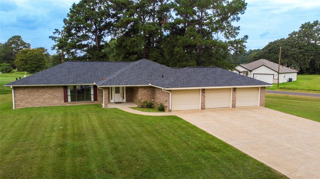 a front view of a house with a yard and trees