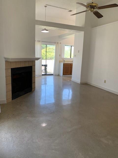 an empty room with windows and fireplace