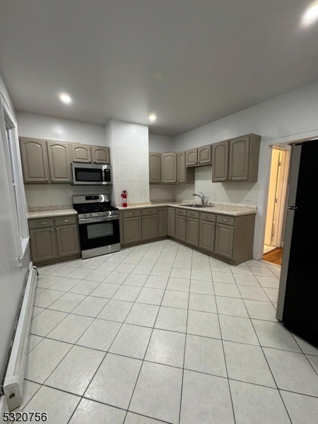 a kitchen with stainless steel appliances a refrigerator sink and cabinets