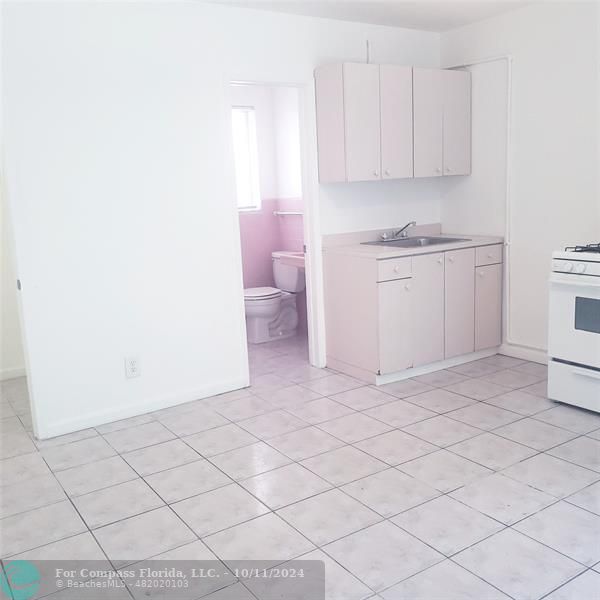 a view of a kitchen with white cabinets and a sink