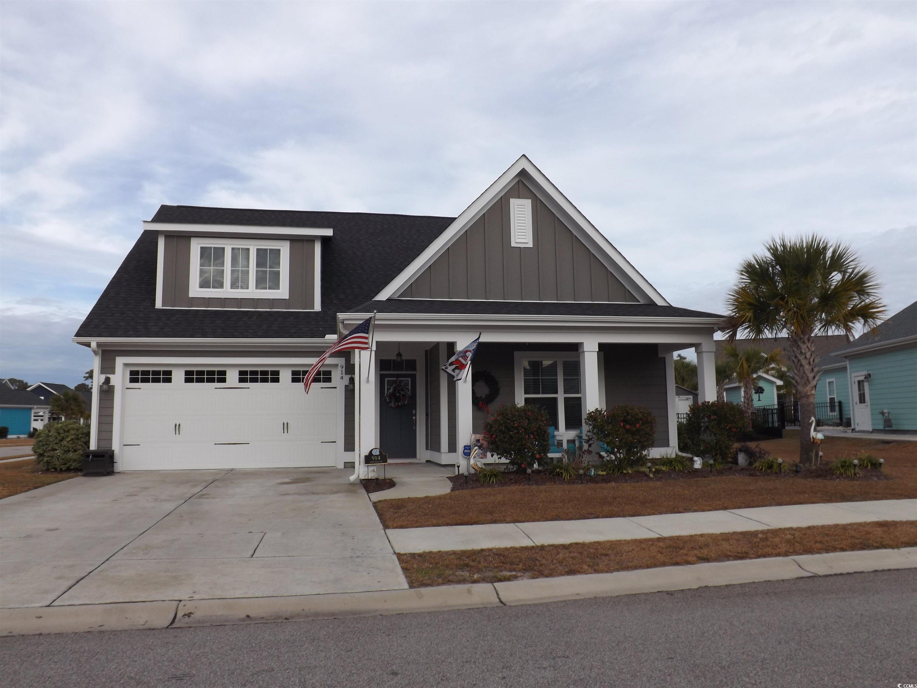 View of front of house featuring a porch and a gar