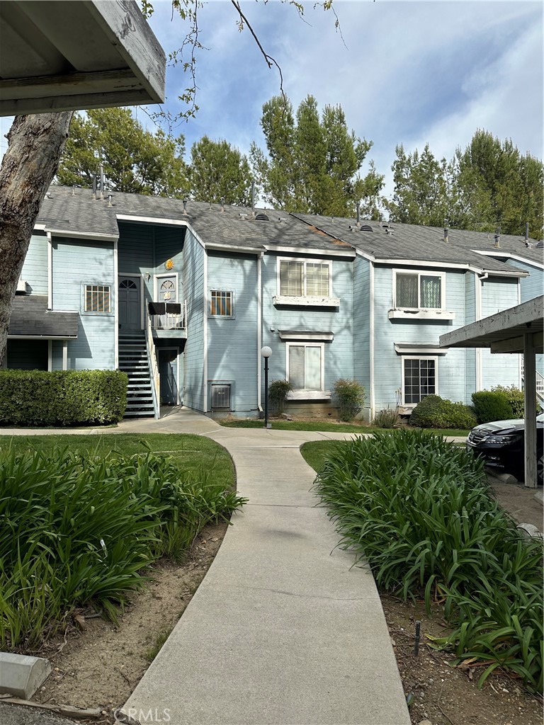 a front view of a house with a yard and potted plants