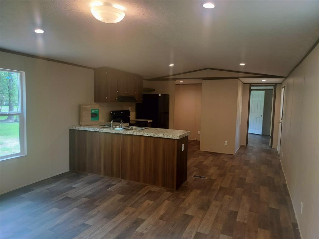 a kitchen with stainless steel appliances a refrigerator and a wooden floor