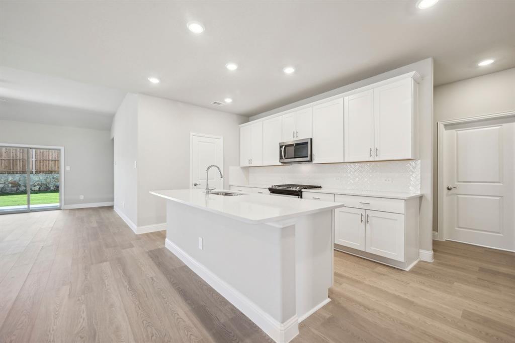 a kitchen with appliances a sink and cabinets