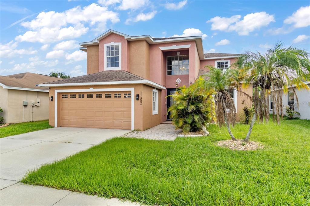 a front view of a house with a yard and garage