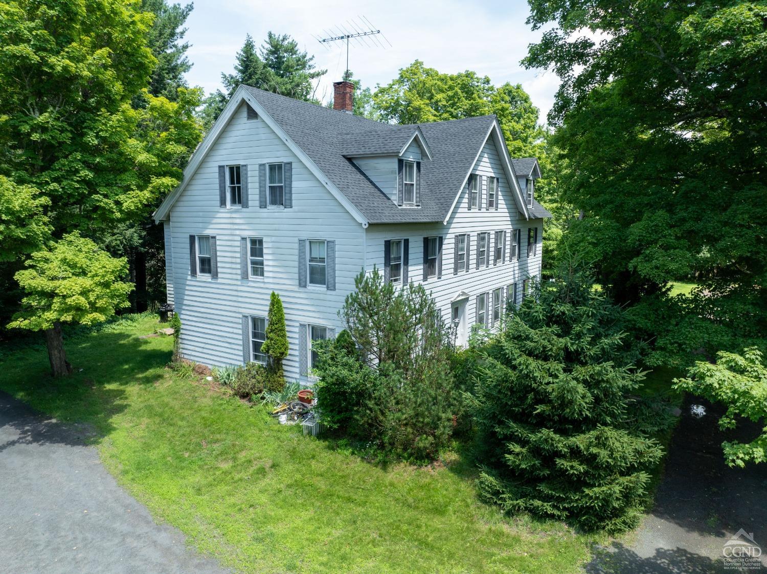 a front view of a house with a yard and trees