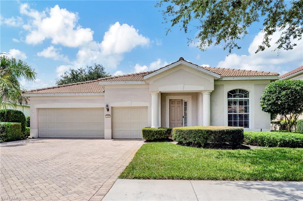 Mediterranean / spanish-style home with a garage and a front lawn