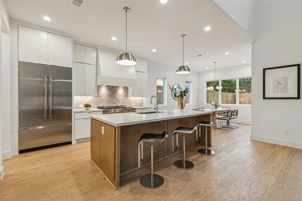 a kitchen with kitchen island granite countertop a sink a counter and stainless steel appliances