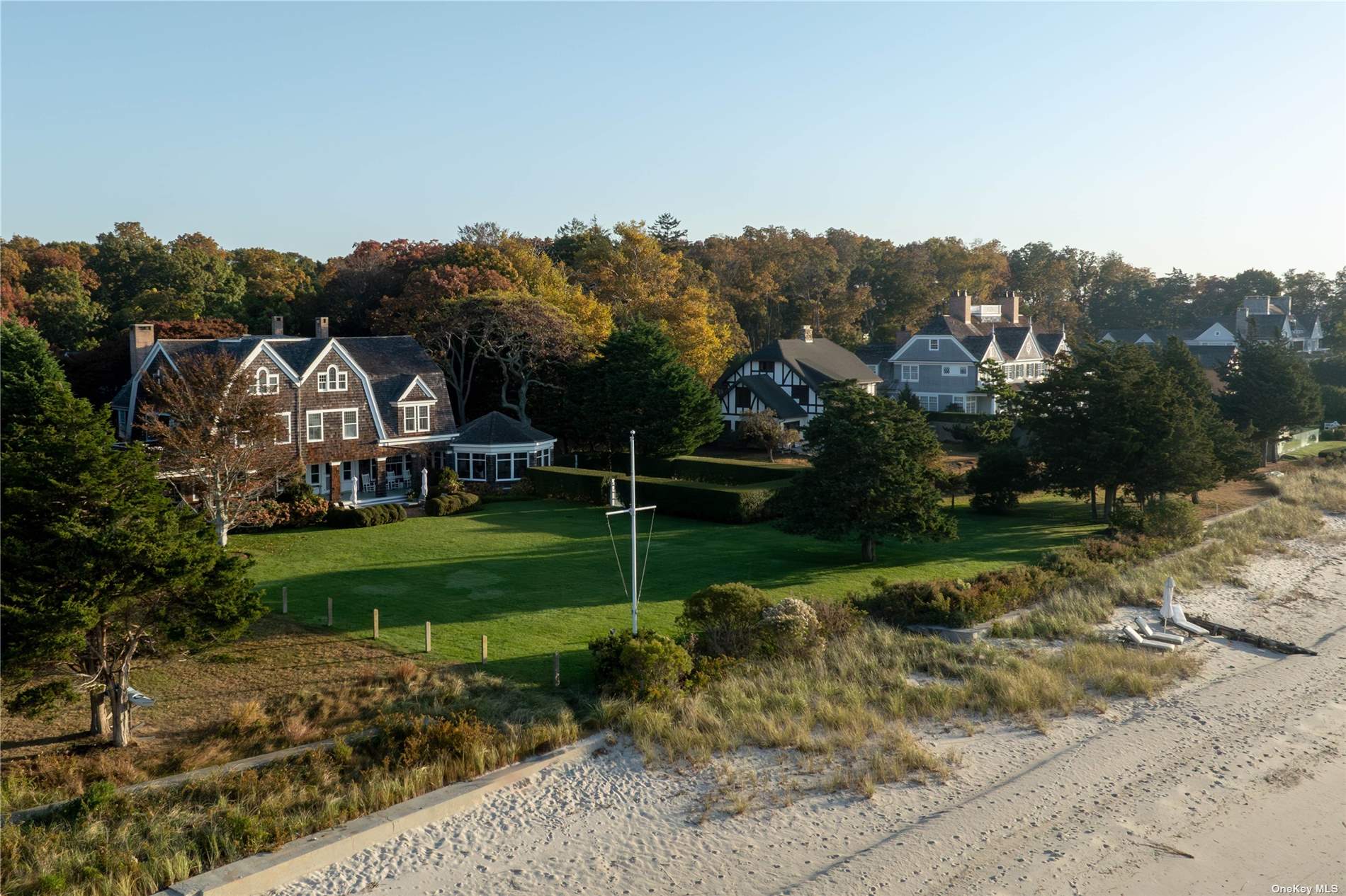 a view of a house with a big yard and a forest