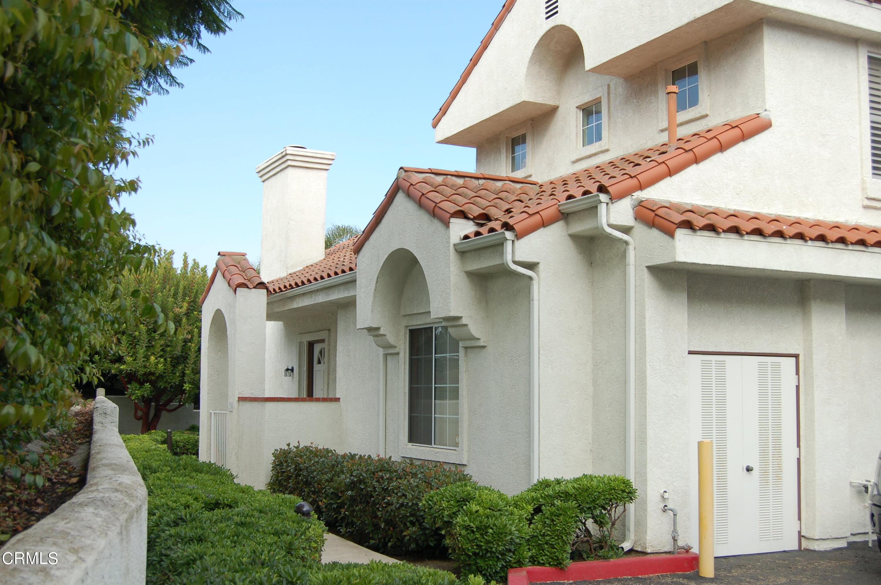 a front view of a house with plants and garage