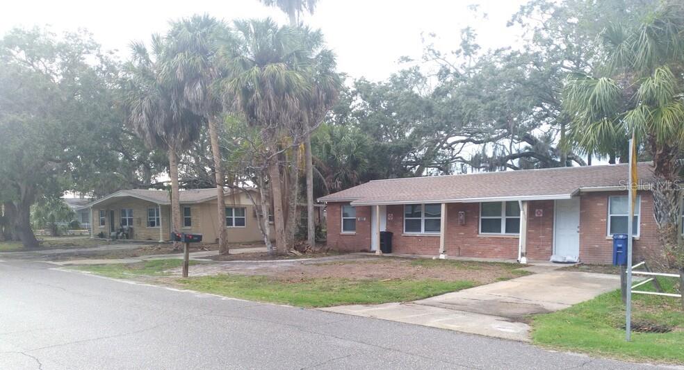 a view of a house with a yard and large tree