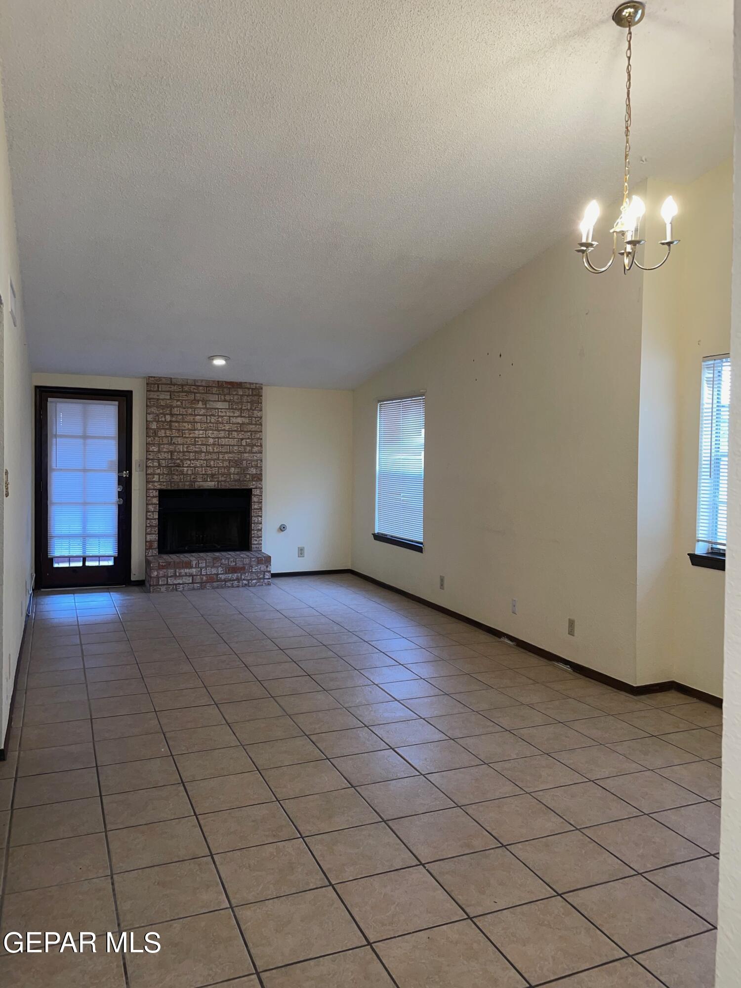 a view of an empty room with a fireplace and a window