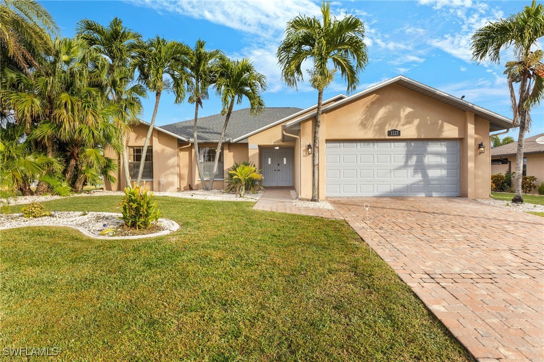 a front view of a house with a yard and palm trees