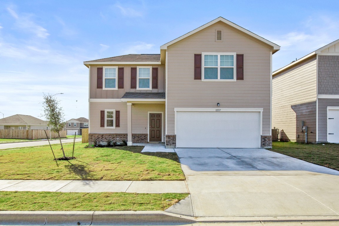 a front view of a house with a yard and garage