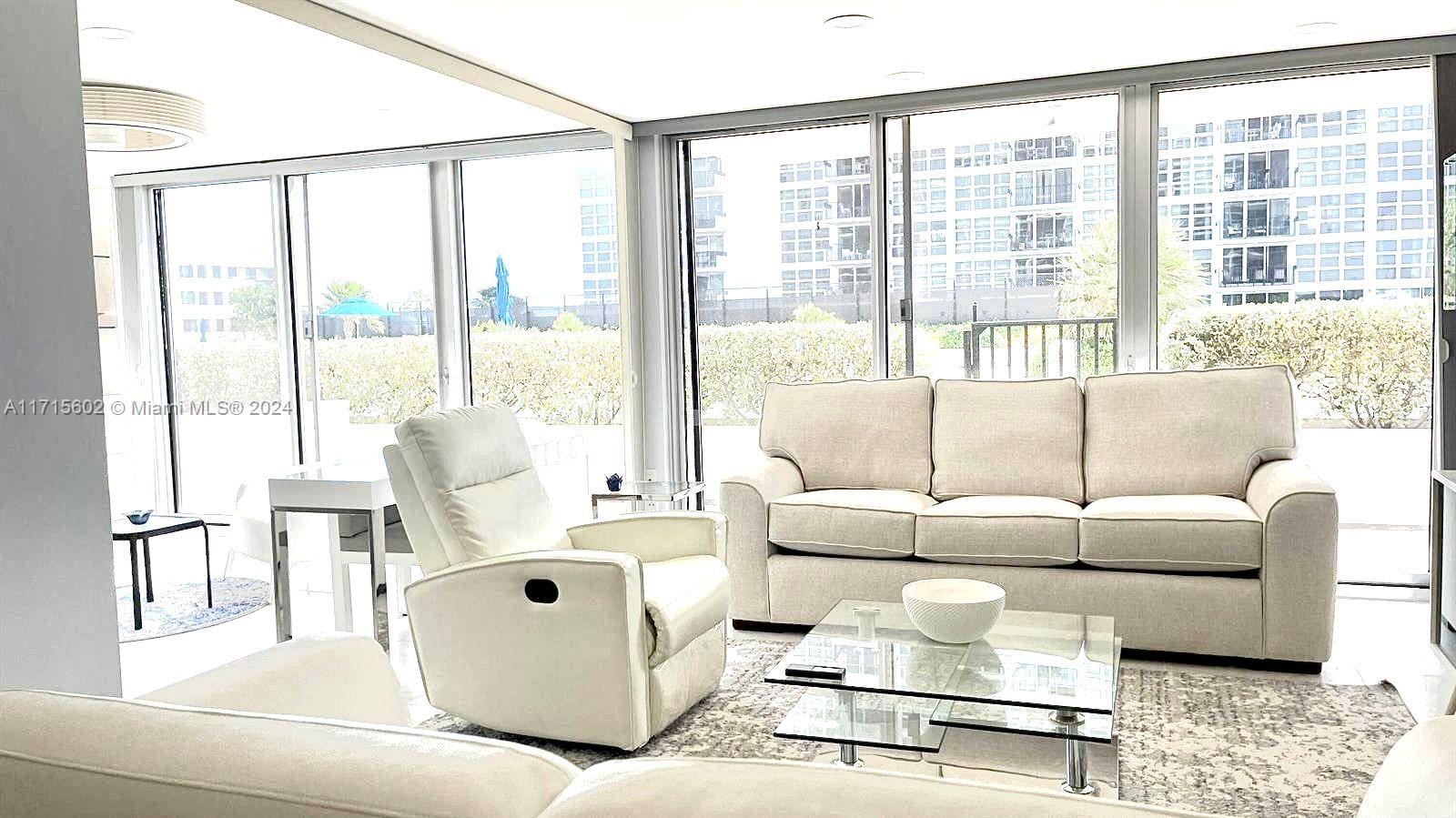 a living room with furniture and large windows