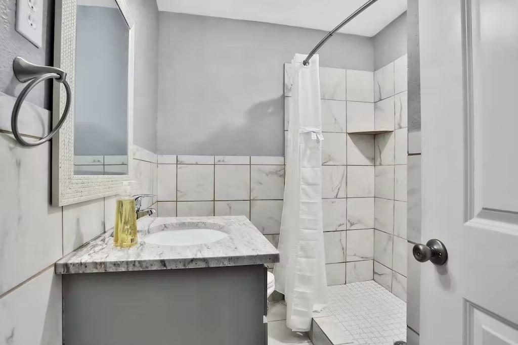 a bathroom with a granite countertop sink toilet and shower