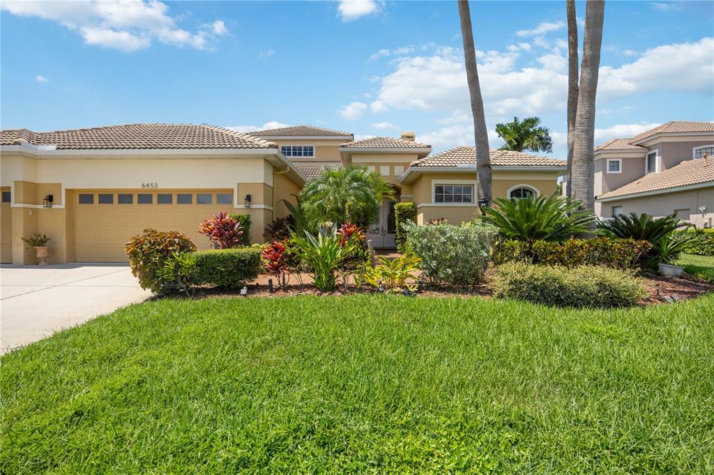 a view of a house with a big yard and potted plants