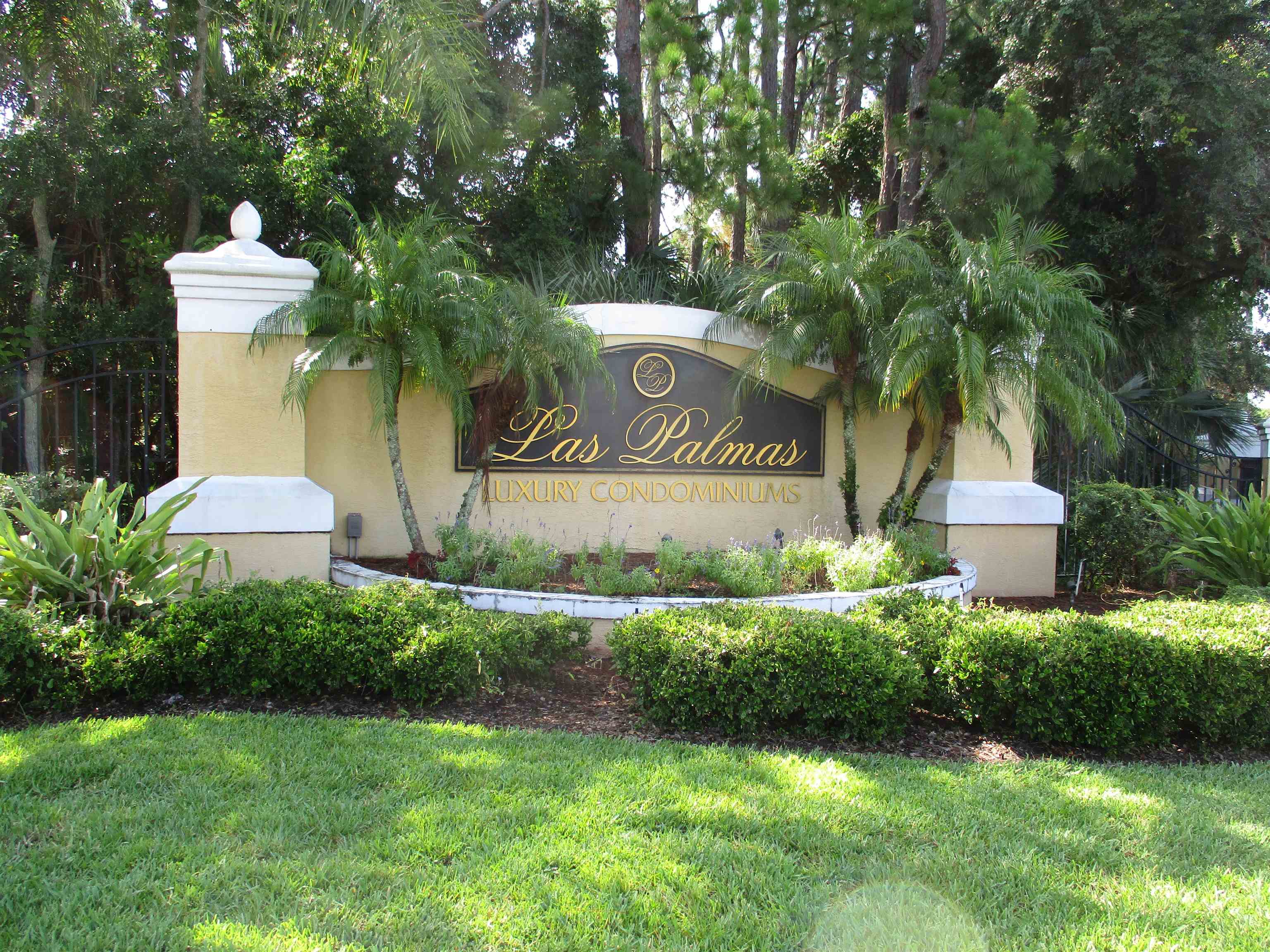 a view of sign board with yard and trees