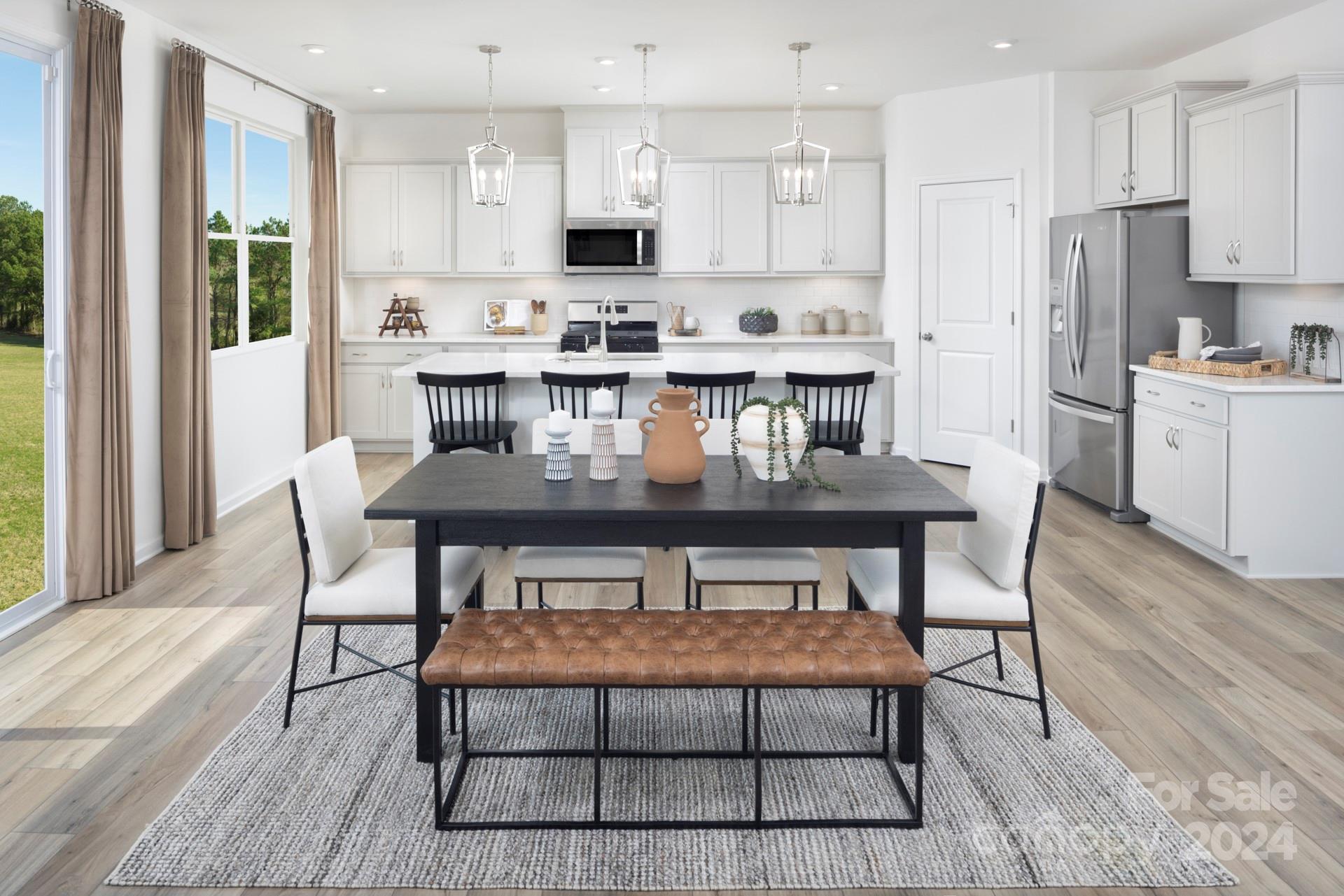 a dining table chairs and a refrigerator in a kitchen