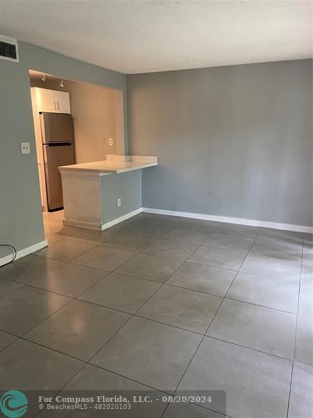 a view of a kitchen with furniture and a refrigerator