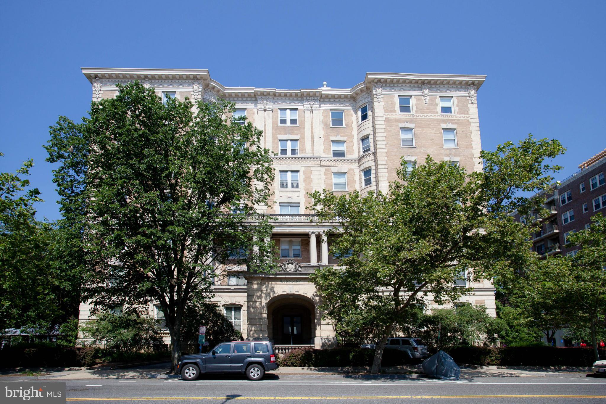 a view of a building and car parked on the side of road