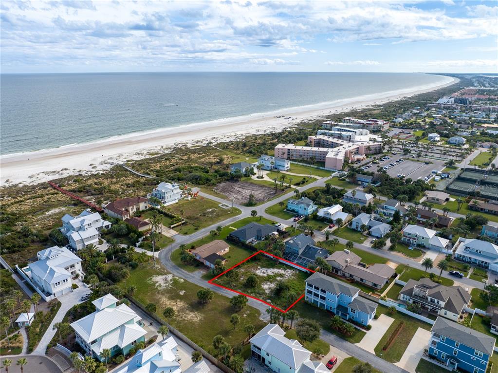 an aerial view of a city with lots of residential buildings and ocean view in back