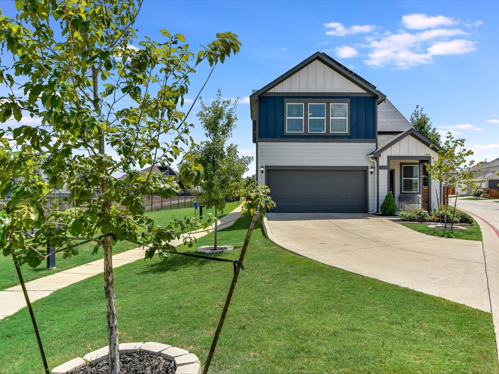 a front view of a house with a yard and trees