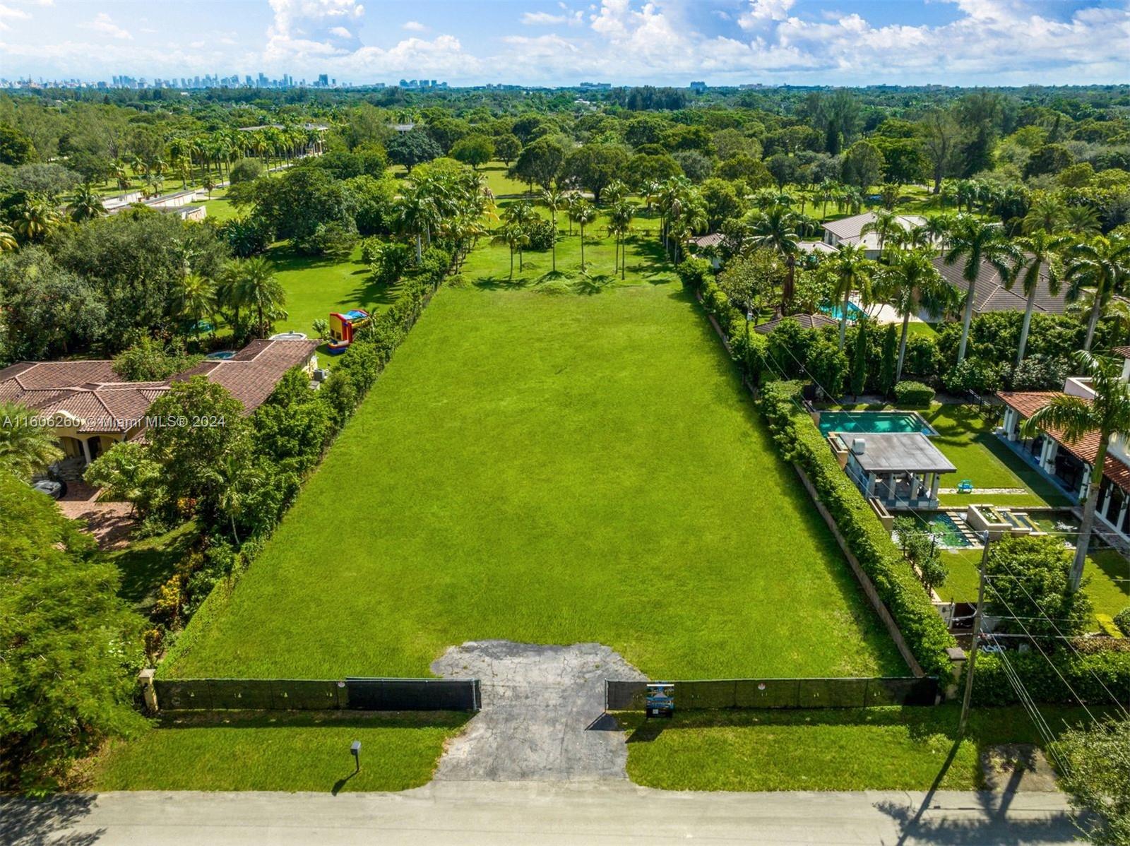 an aerial view of residential houses with outdoor space and trees