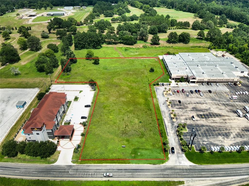 an aerial view of a residential houses with yard and green space