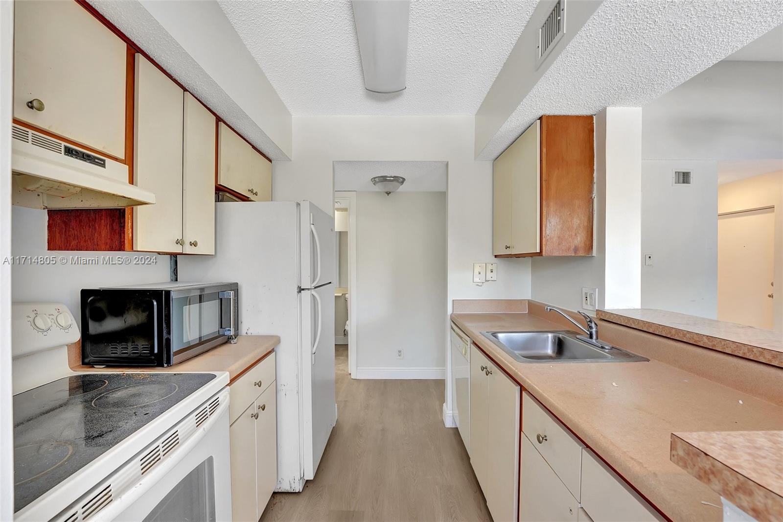 a kitchen with stainless steel appliances granite countertop a sink a stove and a refrigerator