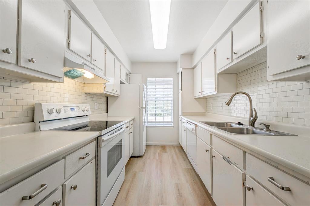 a kitchen with a sink dishwasher a stove and cabinets