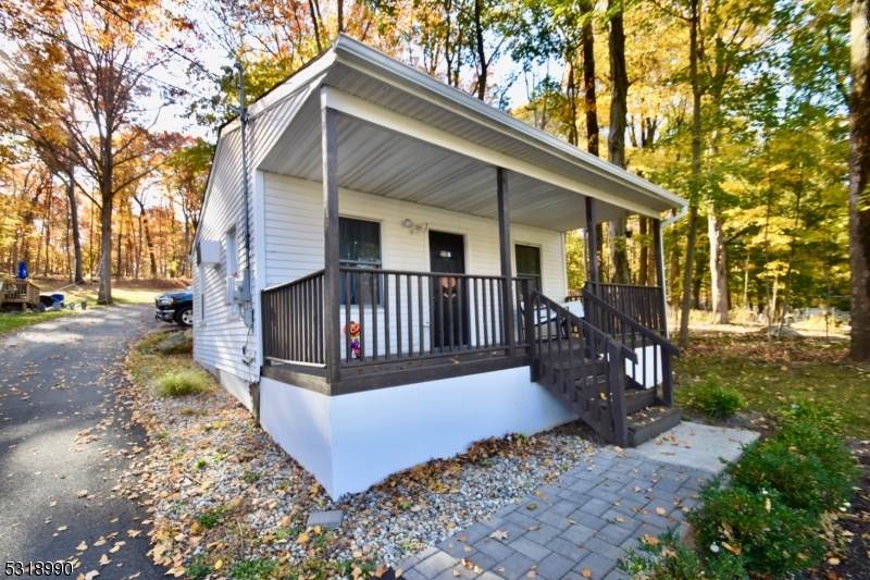 a view of a house with a yard porch and wooden fence