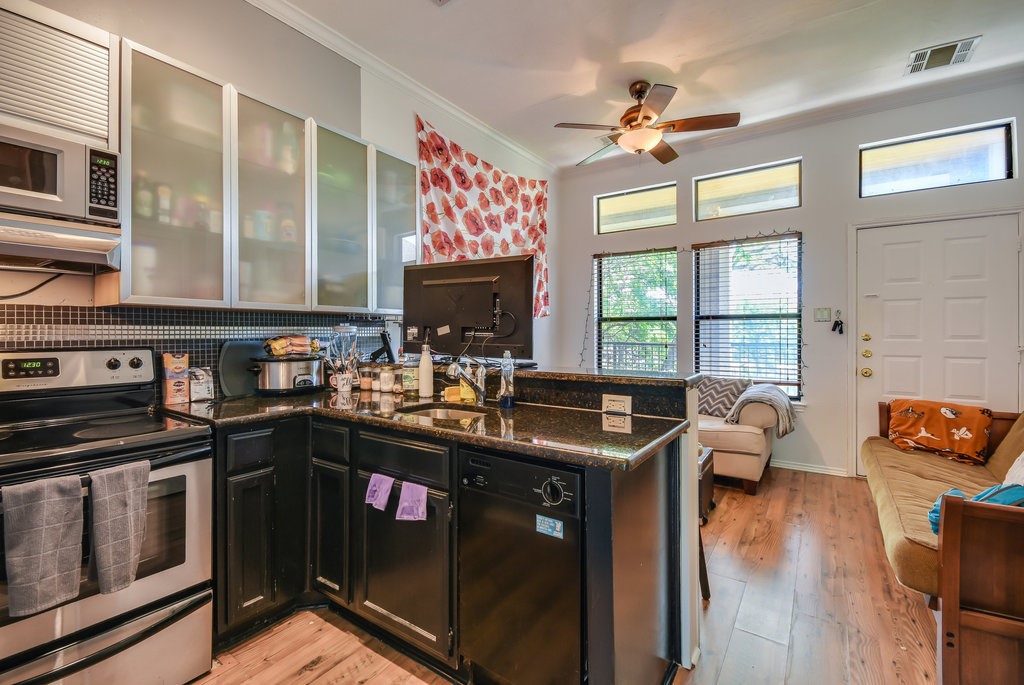 a kitchen with stainless steel appliances granite countertop a stove a sink and a microwave