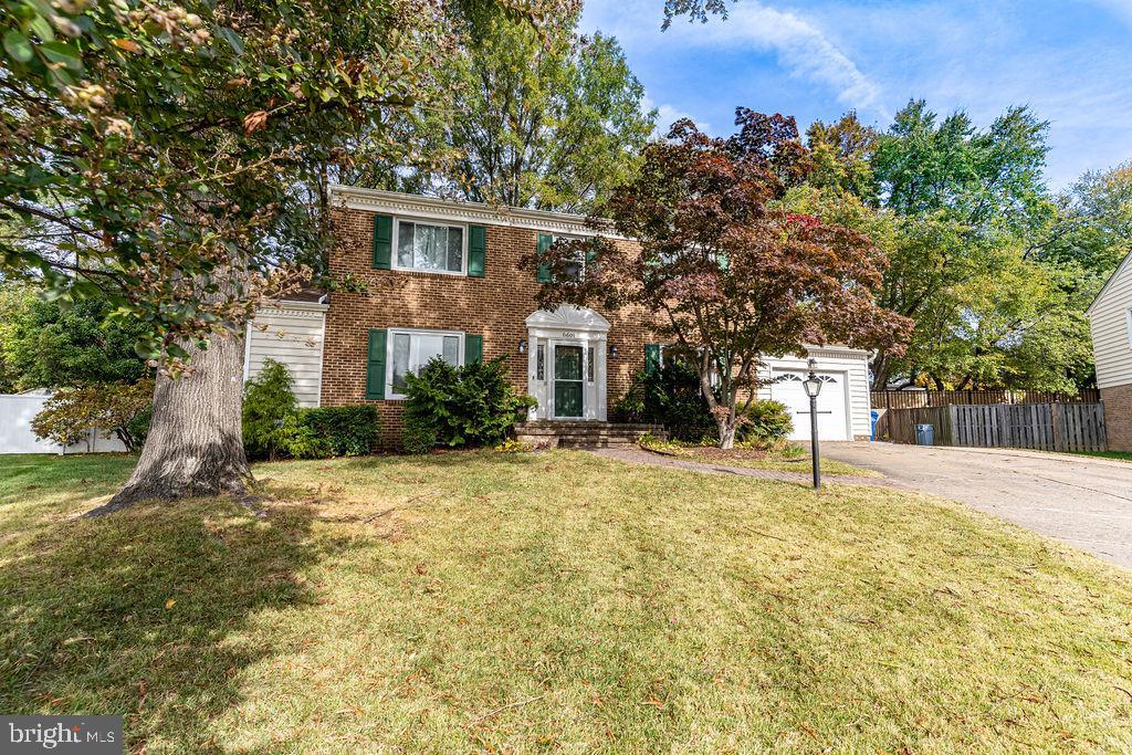 a front view of a house with a yard and trees